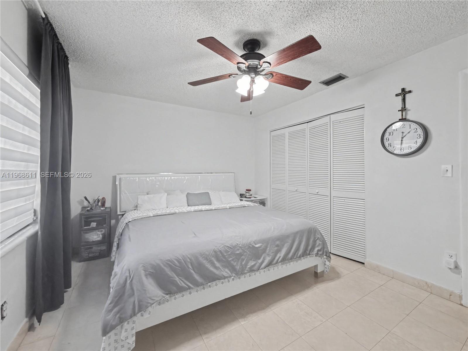 10491 Southwest 122nd Court Miami, FL 33186 - Photo 17 of 25 a bedroom with a large bed and a chandelier