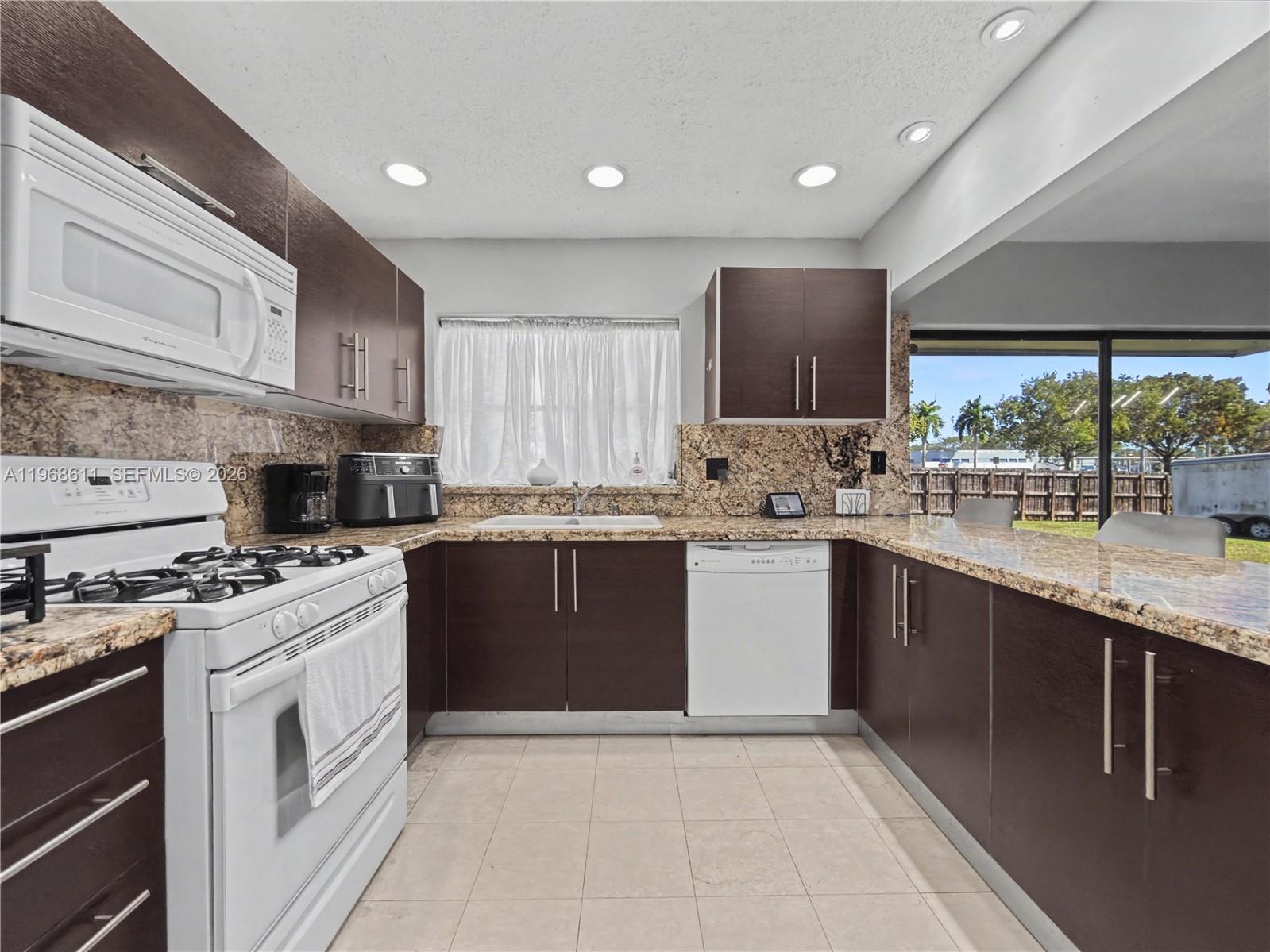 10491 Southwest 122nd Court Miami, FL 33186 - Photo 2 of 25 a kitchen with stainless steel appliances granite countertop a stove sink and cabinets