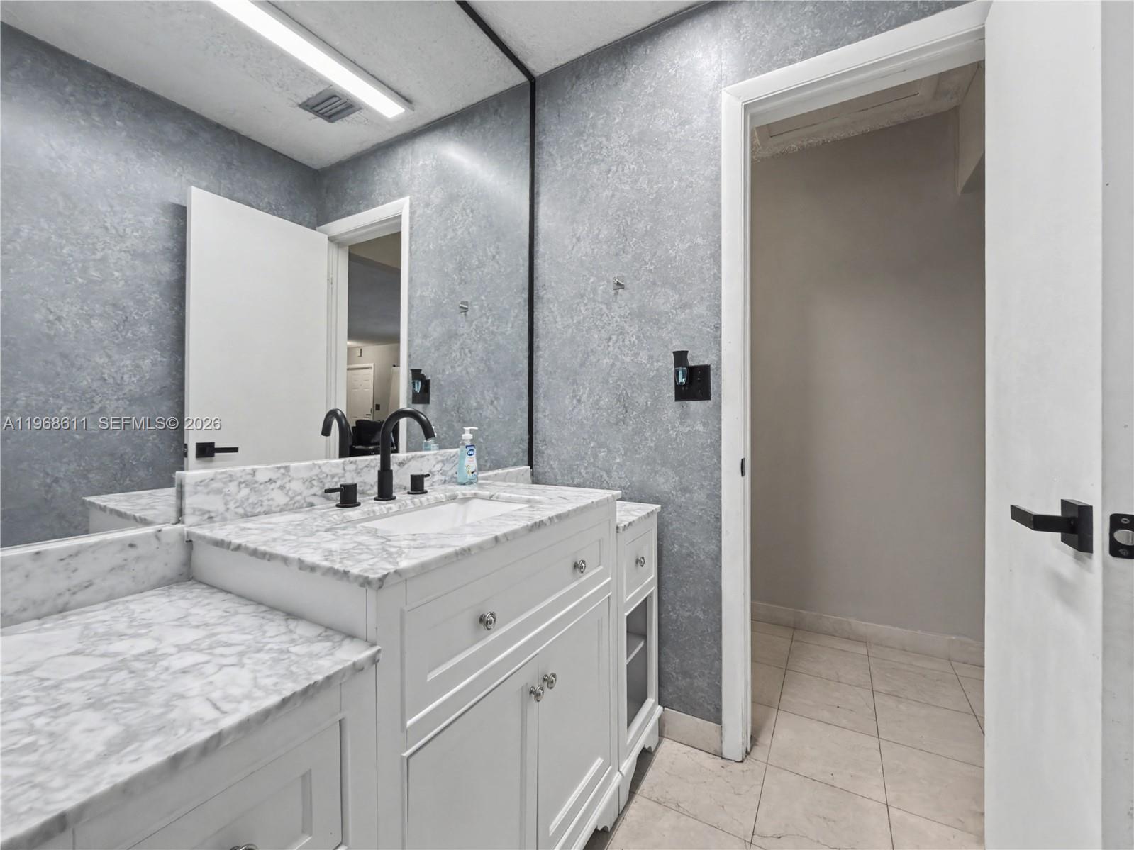 10491 Southwest 122nd Court Miami, FL 33186 - Photo 8 of 25 a bathroom with a granite countertop sink and a mirror