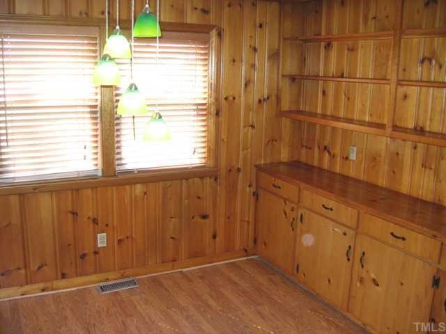 The dining room off the kitchen is a light filled space with warm pine paneling and solid wood built in cabinets and shelves. This is a critical bit of extra space for a home to have.