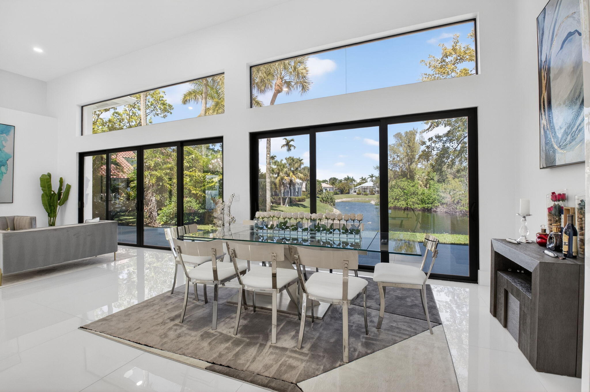 7075 Siena Court Boca Raton, FL 33433 - Photo 18 of 50 a dining room with furniture a flat screen tv and a floor to ceiling window