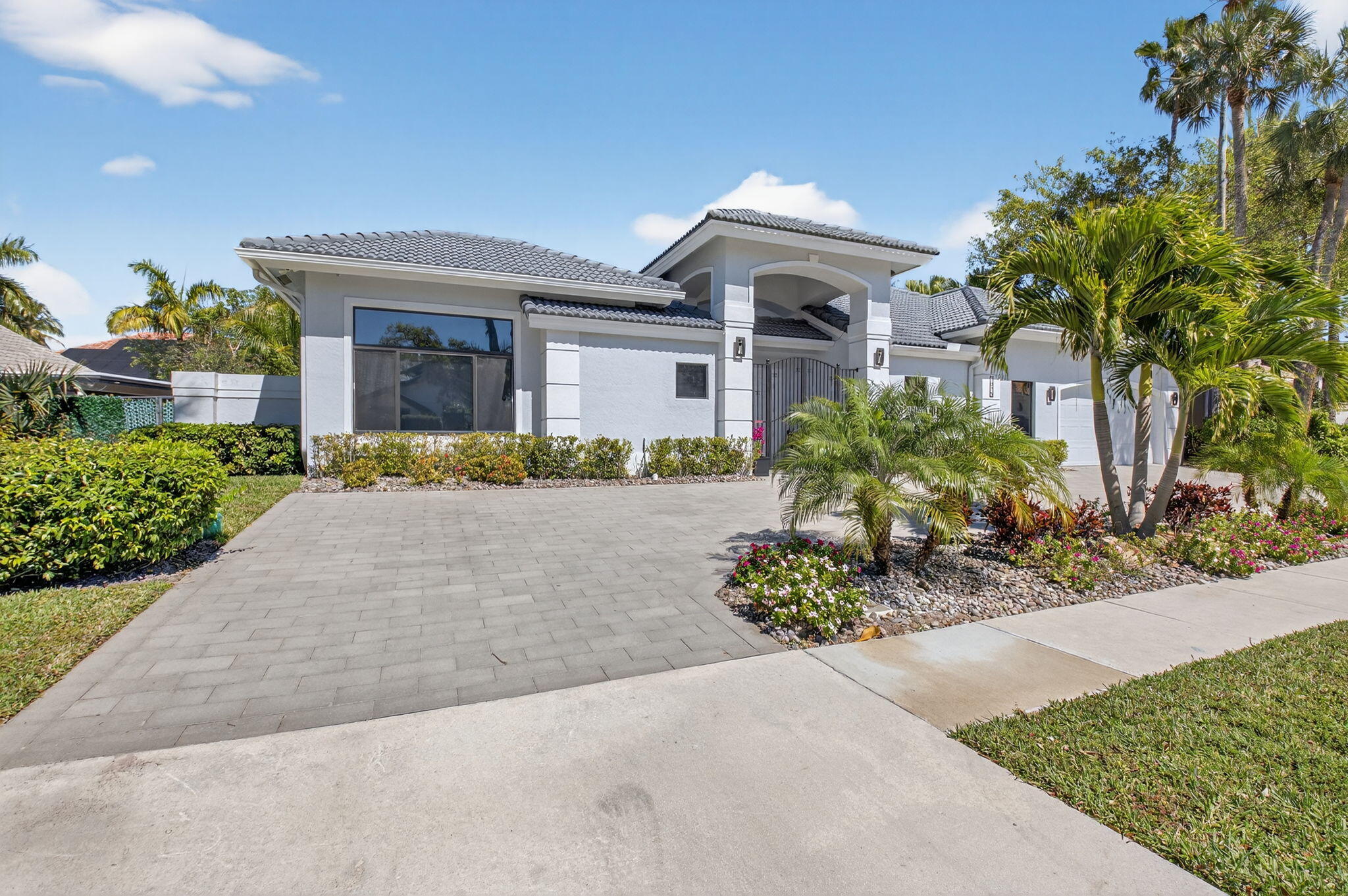7075 Siena Court Boca Raton, FL 33433 - Photo 3 of 50 a front view of a house with a yard and outdoor seating
