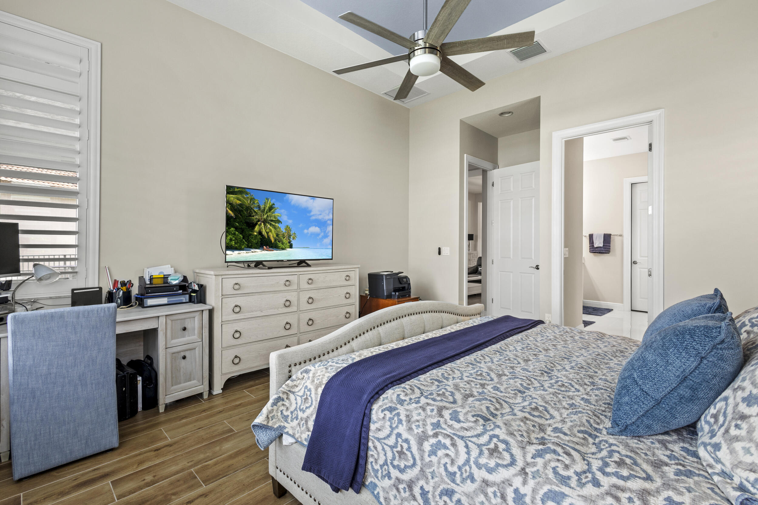 9242 Southwest Pepoli Way Port St. Lucie, FL 34987 - Photo 30 of 71 a spacious bedroom with a bed and a flat screen tv