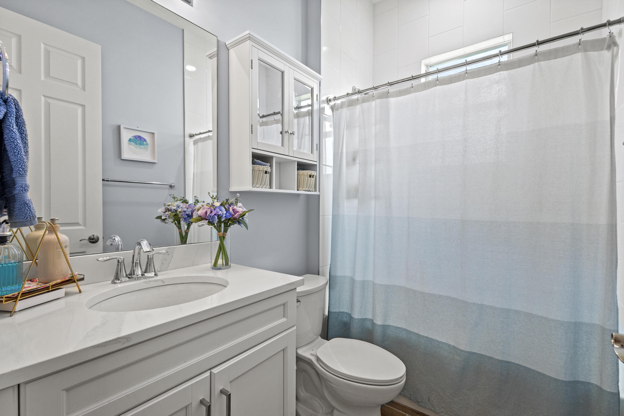 9242 Southwest Pepoli Way Port St. Lucie, FL 34987 - Photo 36 of 71 a bathroom with a sink a mirror a toilet and shower