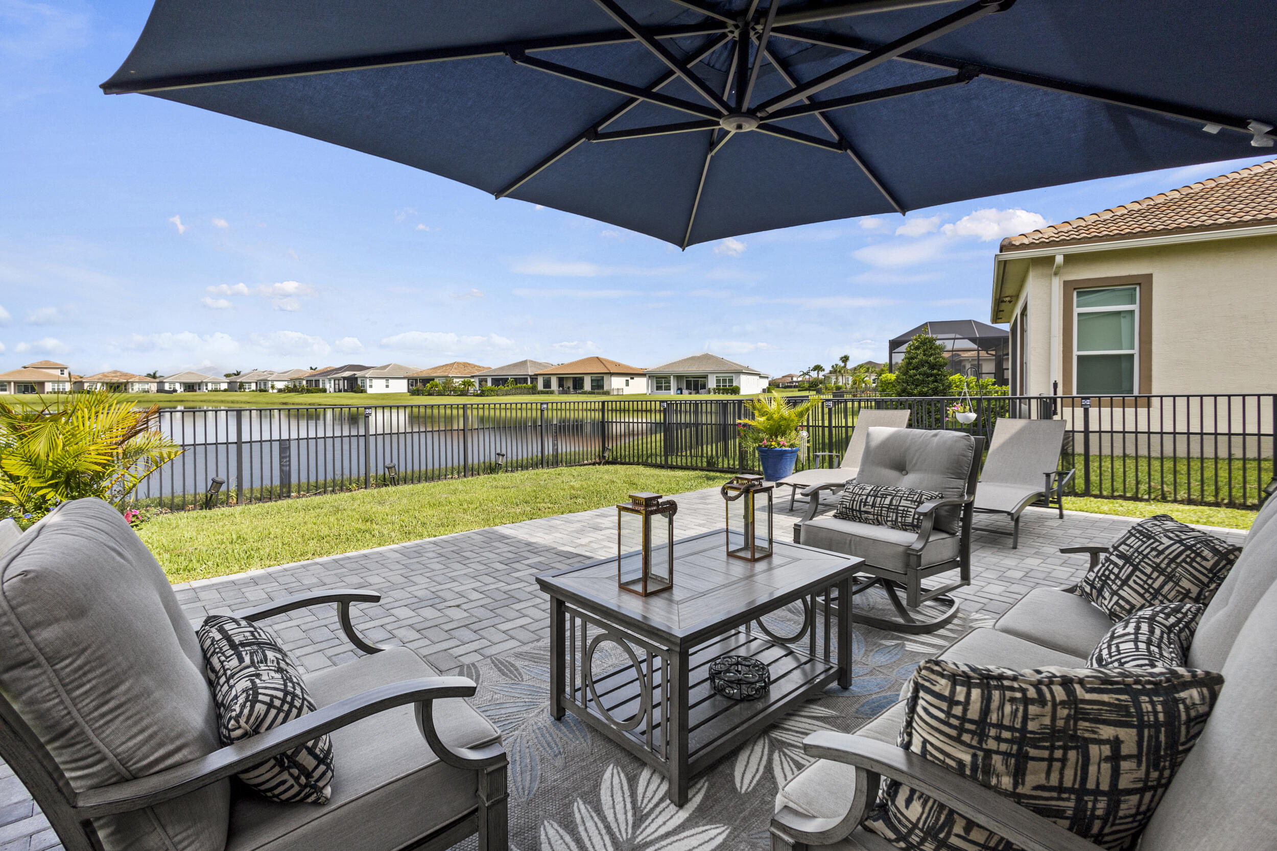 9242 Southwest Pepoli Way Port St. Lucie, FL 34987 - Photo 44 of 71 an outdoor sitting area with furniture and umbrella