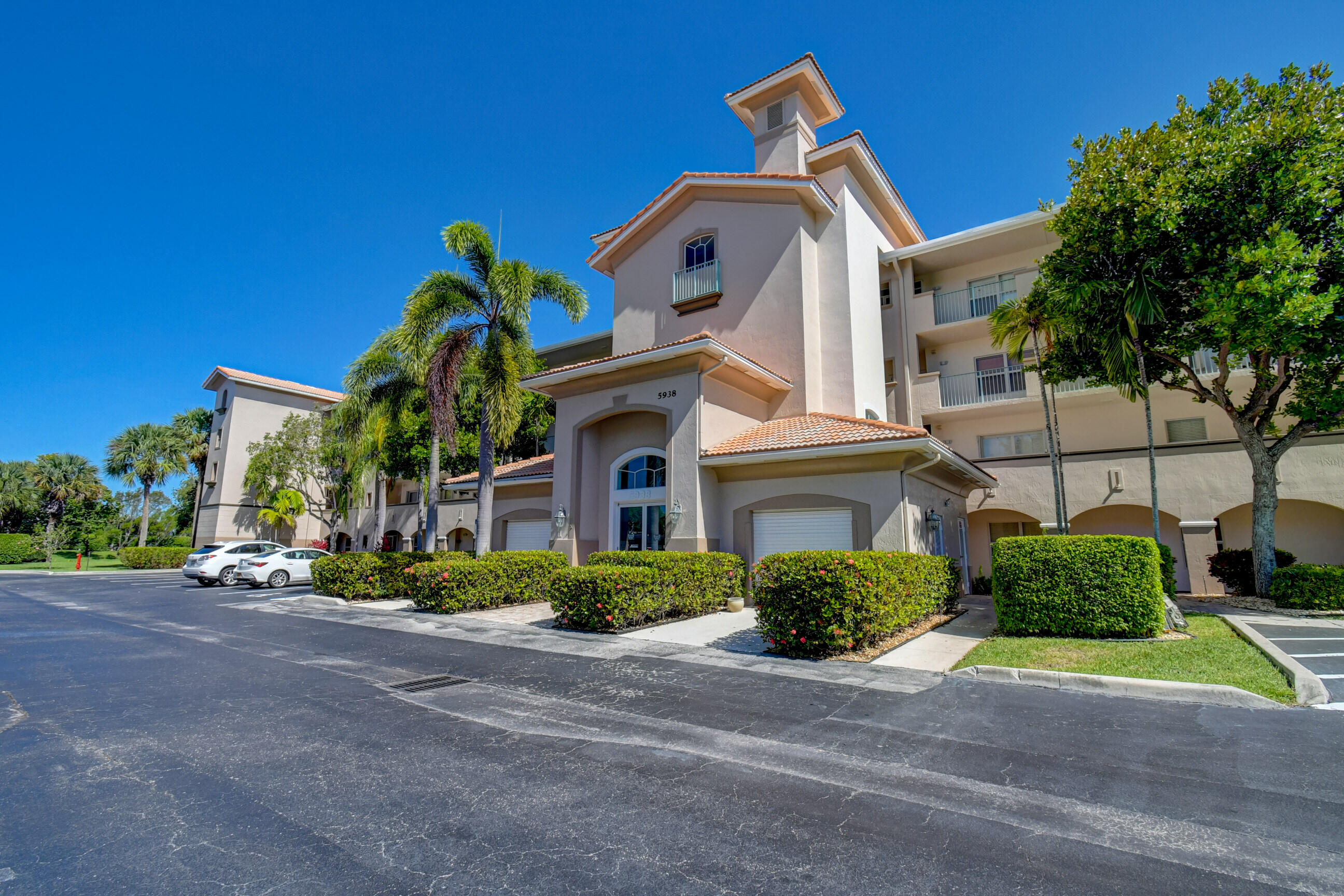 5938 Crystal Shores Drive, Unit 202 Boynton Beach, FL 33437 - Photo 1 of 39 a front view of a house with a yard and potted plants