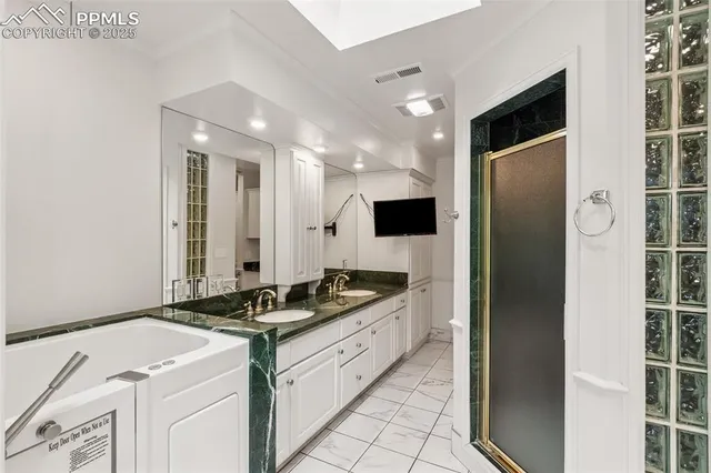 a bathroom with a granite countertop sink mirror and shower