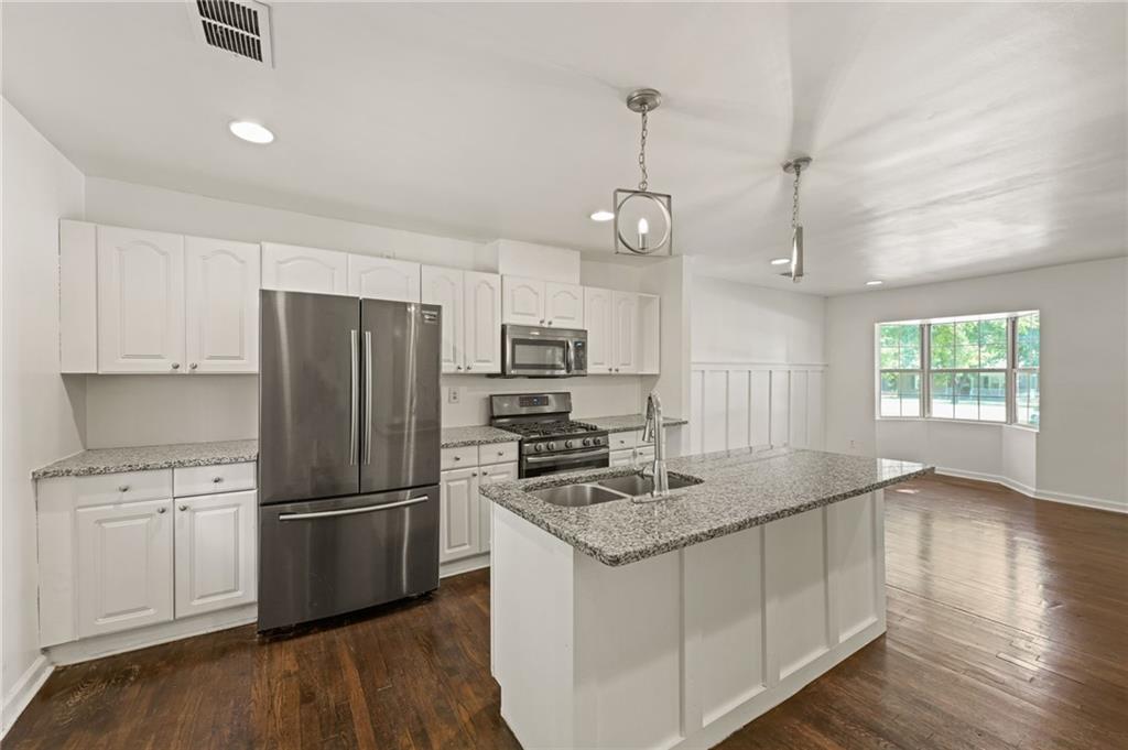 759 Smyrna Road Southwest Conyers, GA 30094 - Photo 12 of 25 a kitchen with refrigerator cabinets and wooden floor