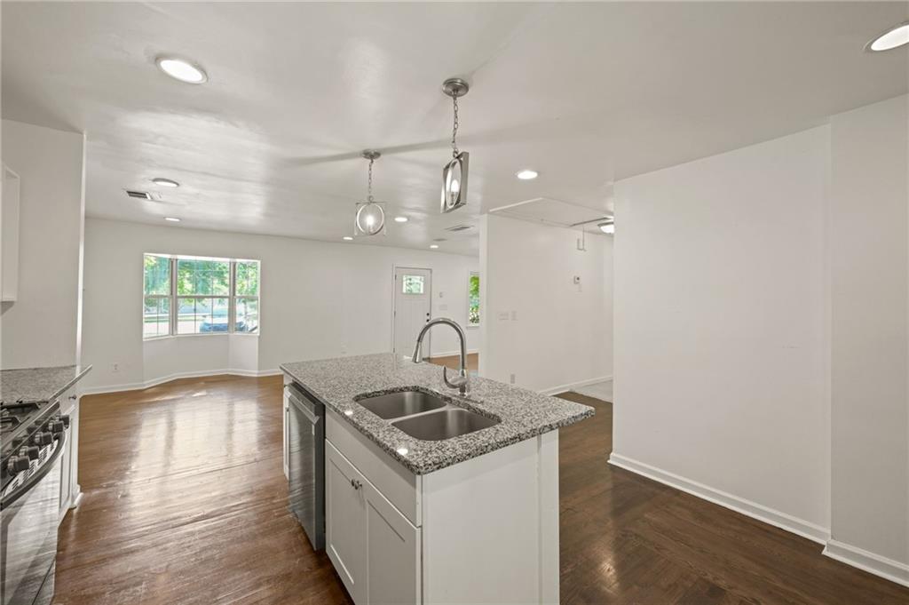 759 Smyrna Road Southwest Conyers, GA 30094 - Photo 13 of 25 a kitchen that has a sink and a stove with wooden floor