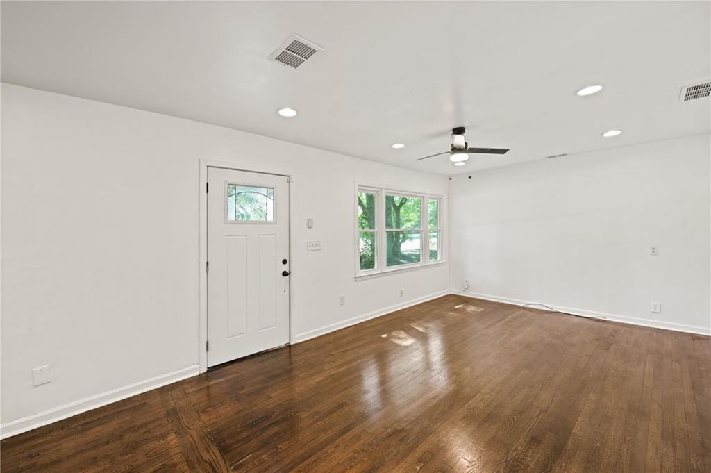 759 Smyrna Road Southwest Conyers, GA 30094 - Photo 3 of 25 an empty room with wooden floor and windows