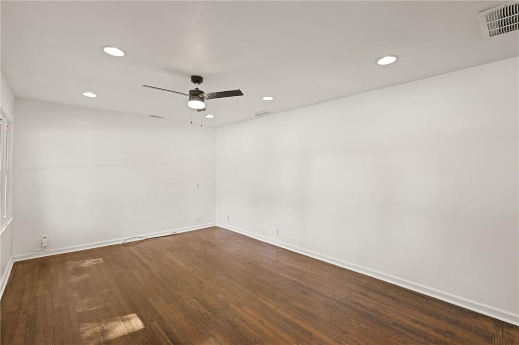 759 Smyrna Road Southwest Conyers, GA 30094 - Photo 4 of 25 an empty room with a ceiling fan and wooden floor