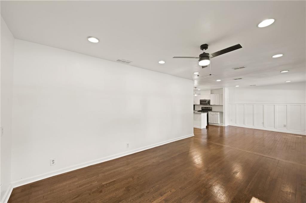 759 Smyrna Road Southwest Conyers, GA 30094 - Photo 6 of 25 an empty room with wooden floor and a ceiling fan