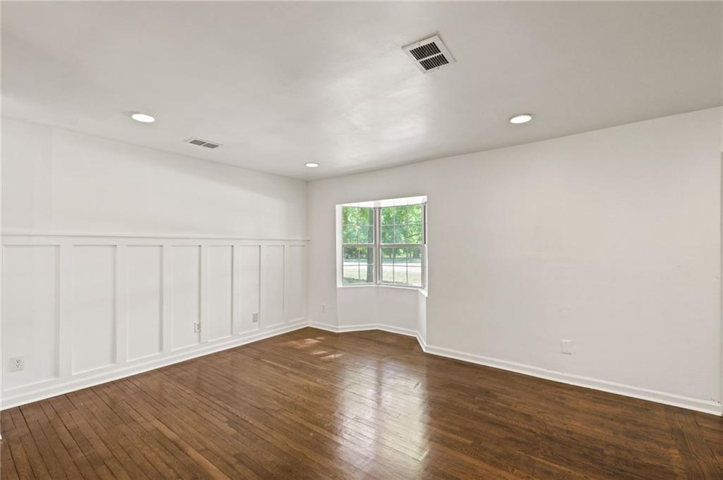 759 Smyrna Road Southwest Conyers, GA 30094 - Photo 7 of 25 an empty room with wooden floor and windows