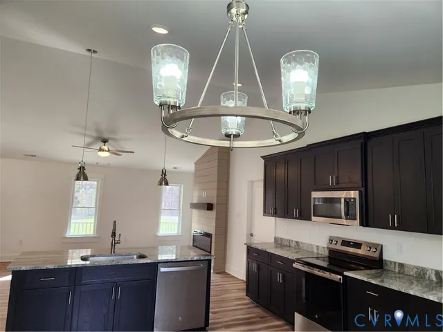 a kitchen with granite countertop wooden cabinets and stainless steel appliances