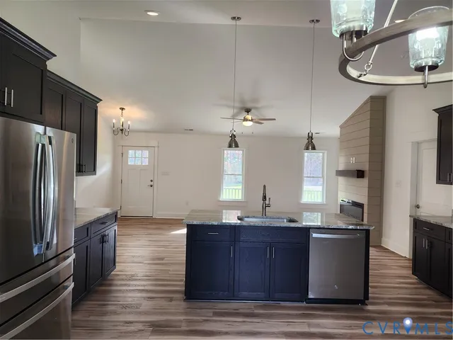 a kitchen with granite countertop a sink cabinets and wooden floor