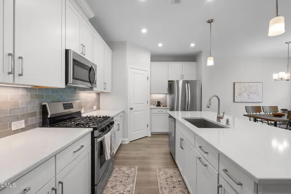 a kitchen with stainless steel appliances granite countertop a sink stove and refrigerator