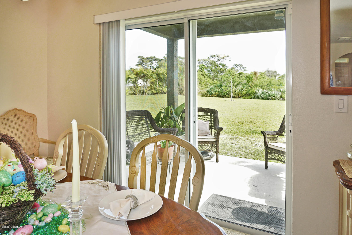 4637 Amaca Bay Lane Melbourne, FL 32935 - Photo 11 of 52 a view of a dining room with wooden floor and a floor to ceiling window