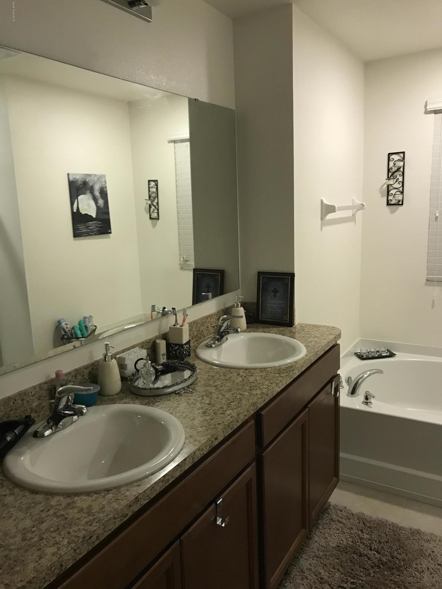 4637 Amaca Bay Lane Melbourne, FL 32935 - Photo 50 of 52 a bathroom with a granite countertop sink and a mirror
