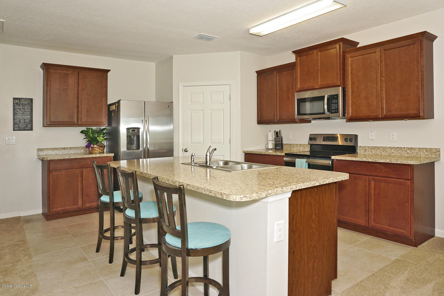 4637 Amaca Bay Lane Melbourne, FL 32935 - Photo 8 of 52 a kitchen with a sink chairs and microwave