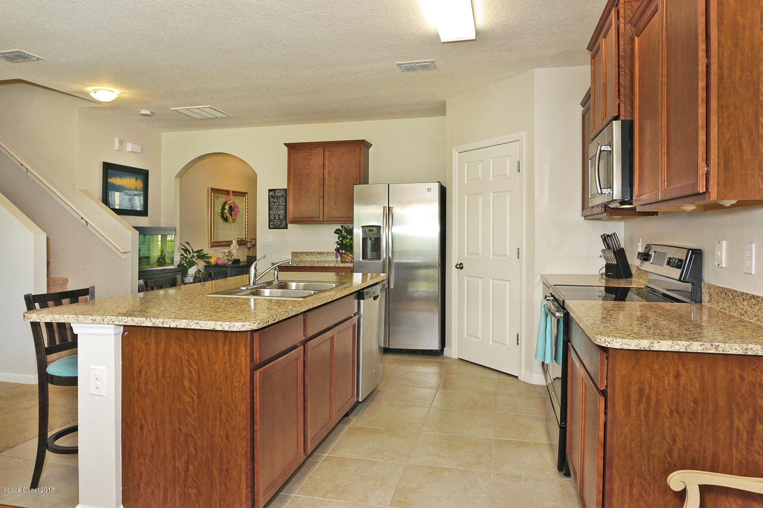4637 Amaca Bay Lane Melbourne, FL 32935 - Photo 9 of 52 a kitchen with stainless steel appliances granite countertop a sink stove and refrigerator