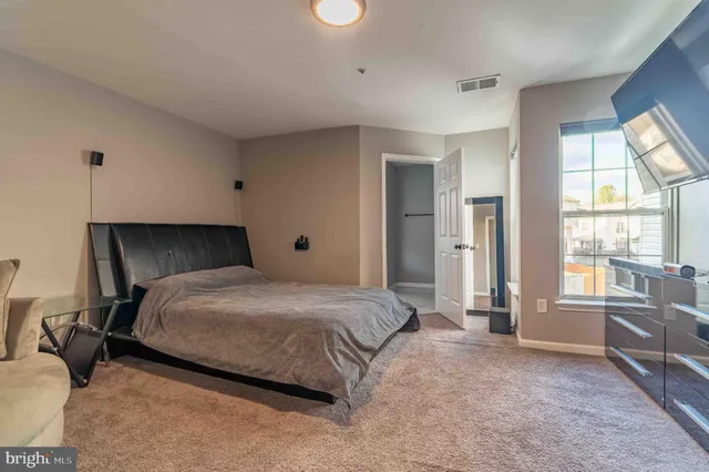 a bedroom with a bed and large windows