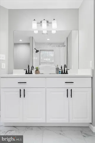 a bathroom with a sink vanity and mirror