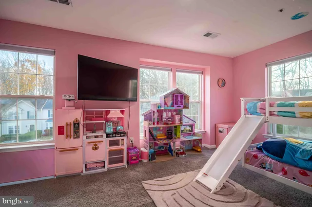 a living room with furniture a flat screen tv and a window