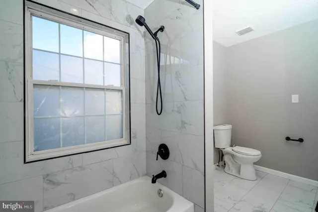 a bathroom with a toilet tub and shower