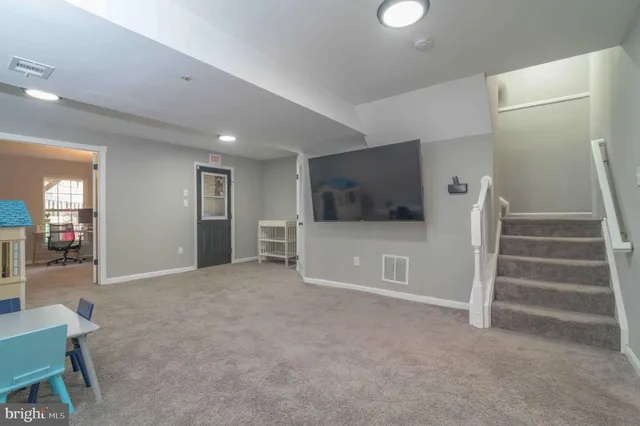 a view of a livingroom with wooden furniture and a ceiling fan