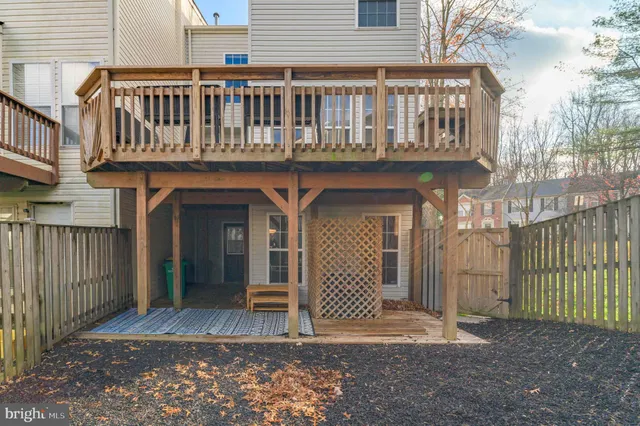a view of a house with a large window and wooden fence