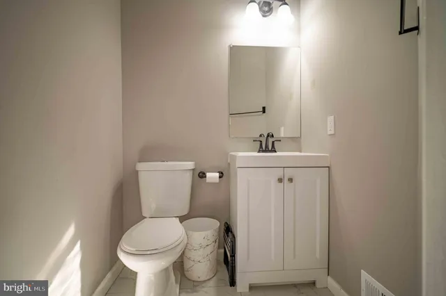 a bathroom with a sink toilet and a mirror