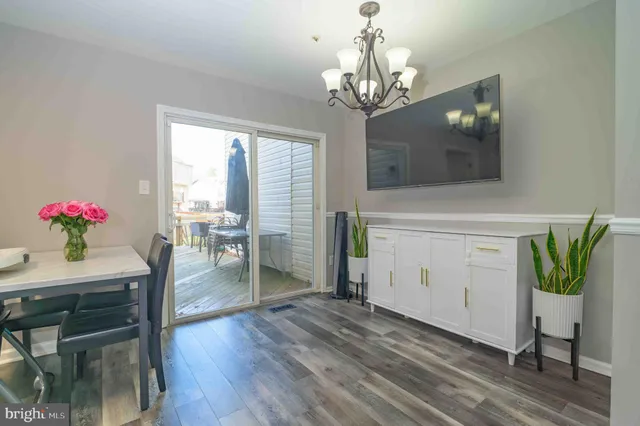 a dining room with furniture potted plants and wooden floor