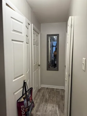 a view of a hallway with closet and a window