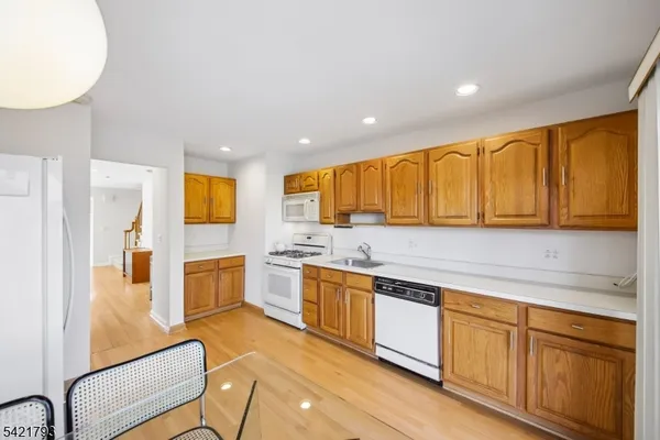 a large kitchen with stainless steel appliances granite countertop a lot of counter space and wooden floors