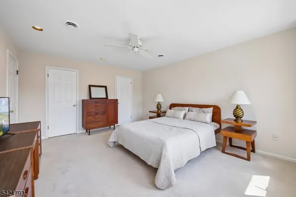 a spacious bedroom with a bed and a chandelier