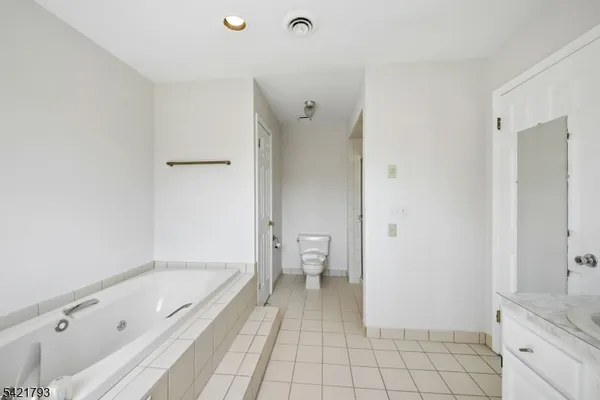 a bathroom with a granite countertop bathtub shower and toilet