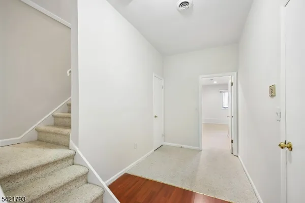 a view of a hallway with wooden floor and entryway
