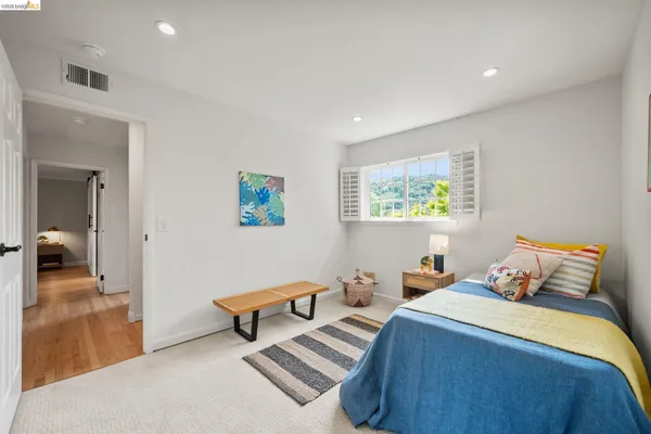 a bedroom with a bed and a view of living room