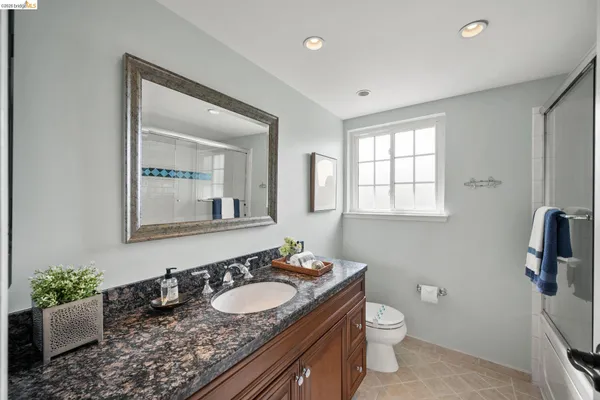 a bathroom with a granite countertop sink and a mirror