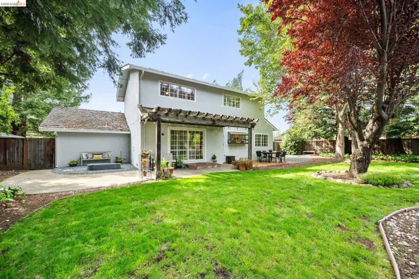 a view of house with a yard and potted plants