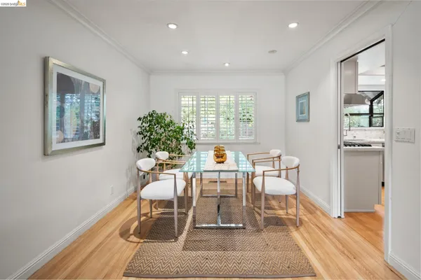 a dining room with wooden floor and a potted plant