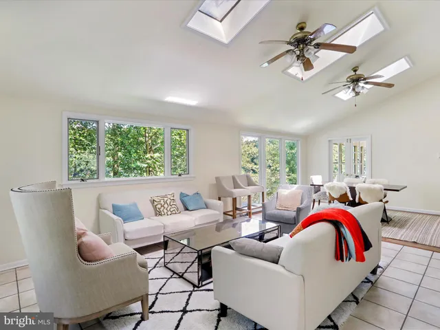 a living room with furniture a large window and wooden floor
