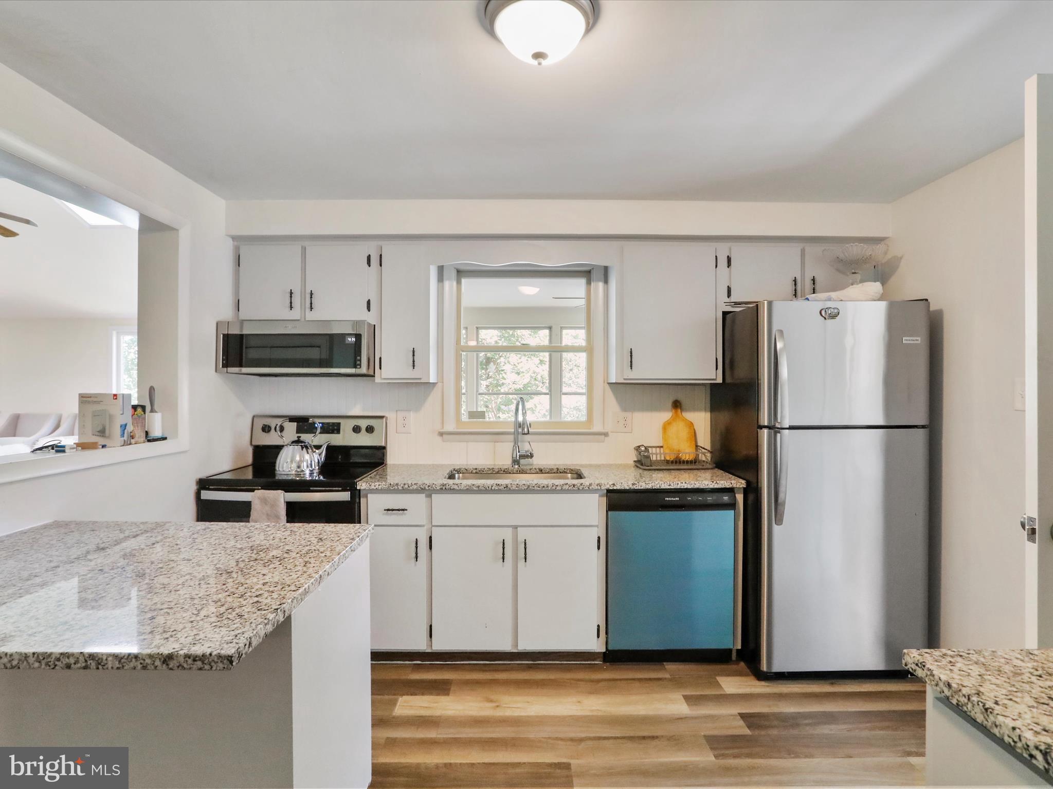 999 Aspero Lane Falling Waters, WV 25419 - Photo 21 of 57 a kitchen with granite countertop a refrigerator stove microwave and sink