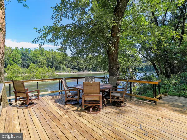 a view of deck with furniture and trees