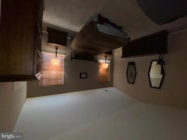 a bedroom with a bed windows and painting on the wall