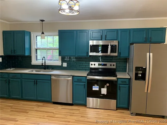 a kitchen with stainless steel appliances granite countertop a refrigerator stove and microwave
