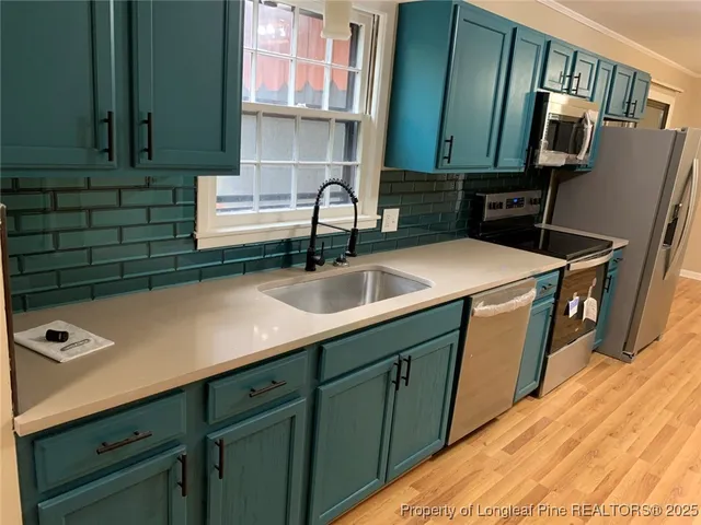 a kitchen with stainless steel appliances granite countertop a sink a stove and refrigerator