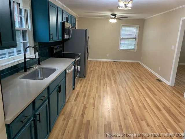 a kitchen with a sink and wooden floor