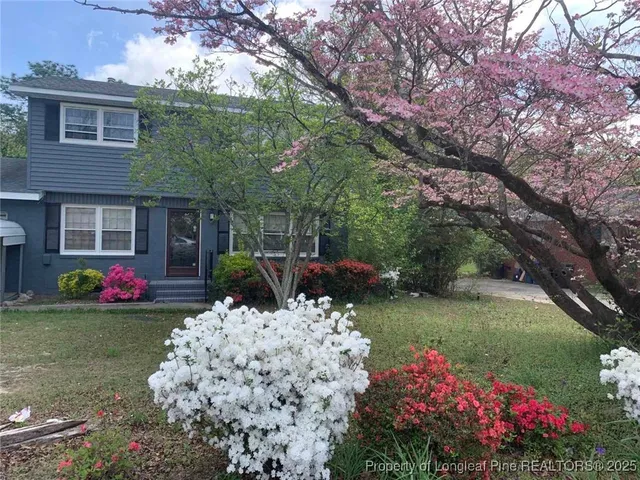 a view of a house with a yard and garden