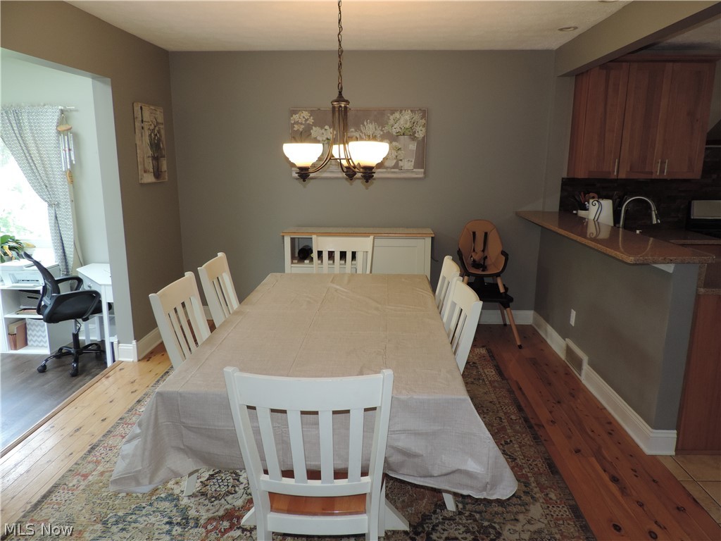 24770 Maple Ridge Road Westlake, OH 44145 - Photo 11 of 26 Dining area featuring hardwood / wood-style floors and a notable chandelier